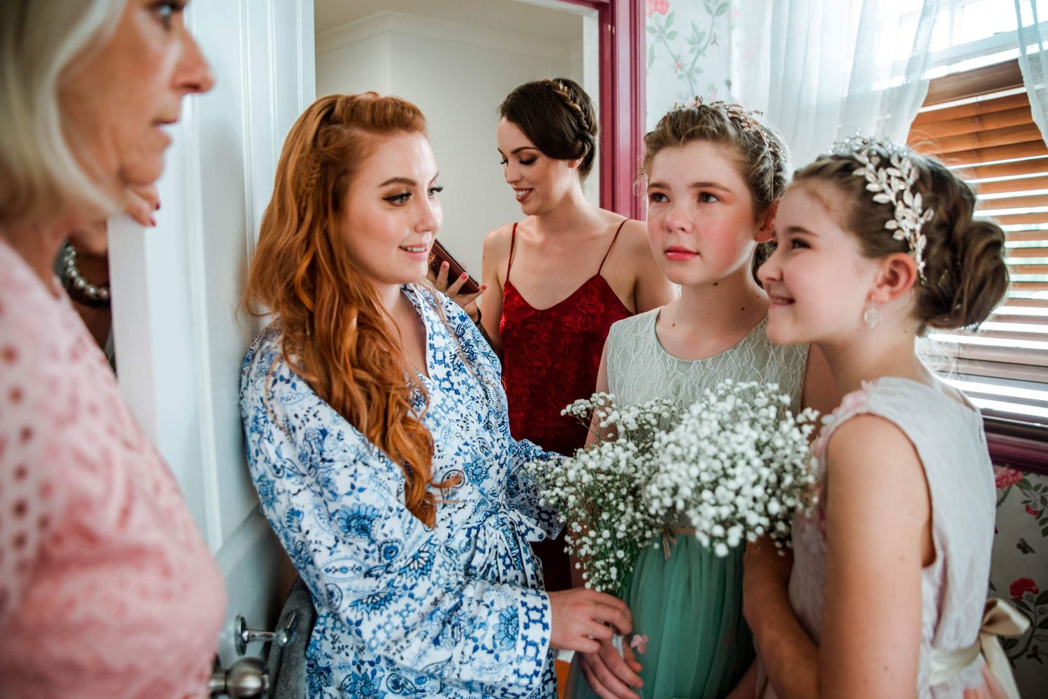 Bridesmaids gather together wearing pastel dresses, with delicate baby's breath flowers adding a soft romantic touch.