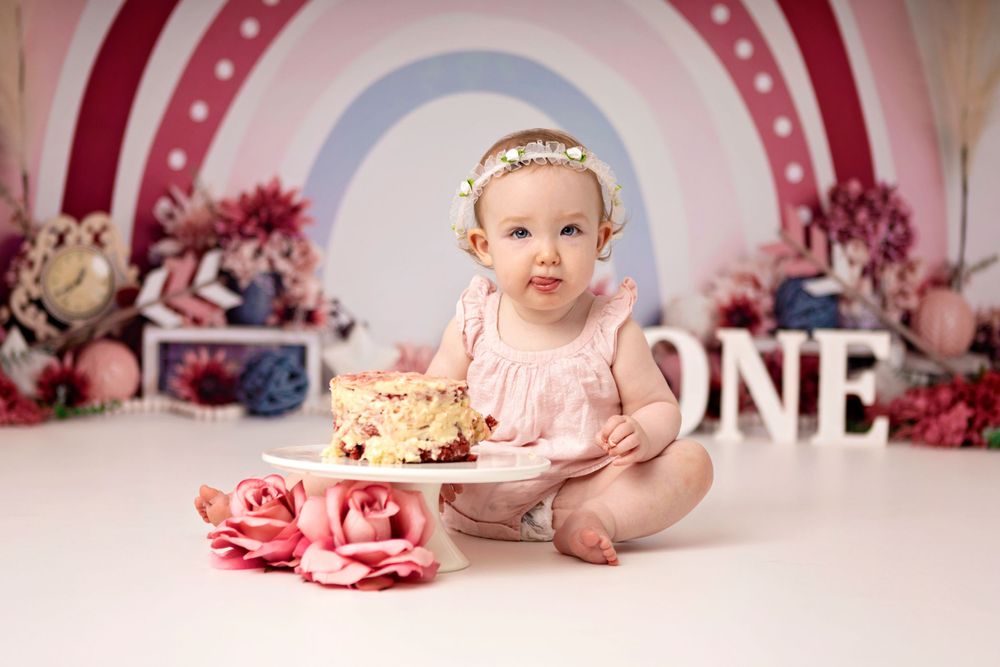 First birthday cake smash setup with pink decorations and floral backdrop. Photography Halifax