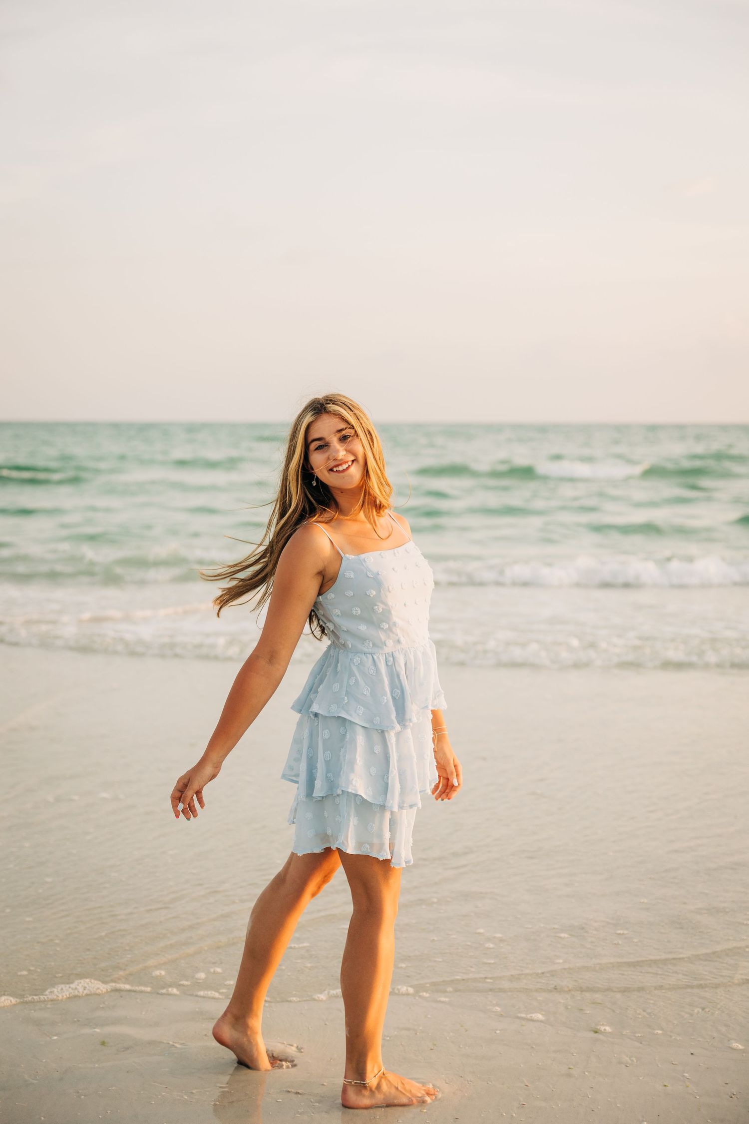 Highschool Senior posing on Siesta Key Beach at sunset photographed by Sarasota Photographer.