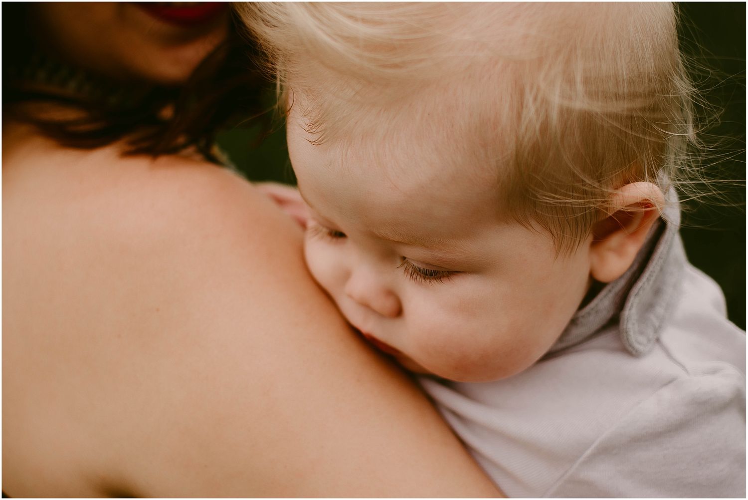 Close-up photo showing an intimate bonding moment between parent and baby in soft lighting.