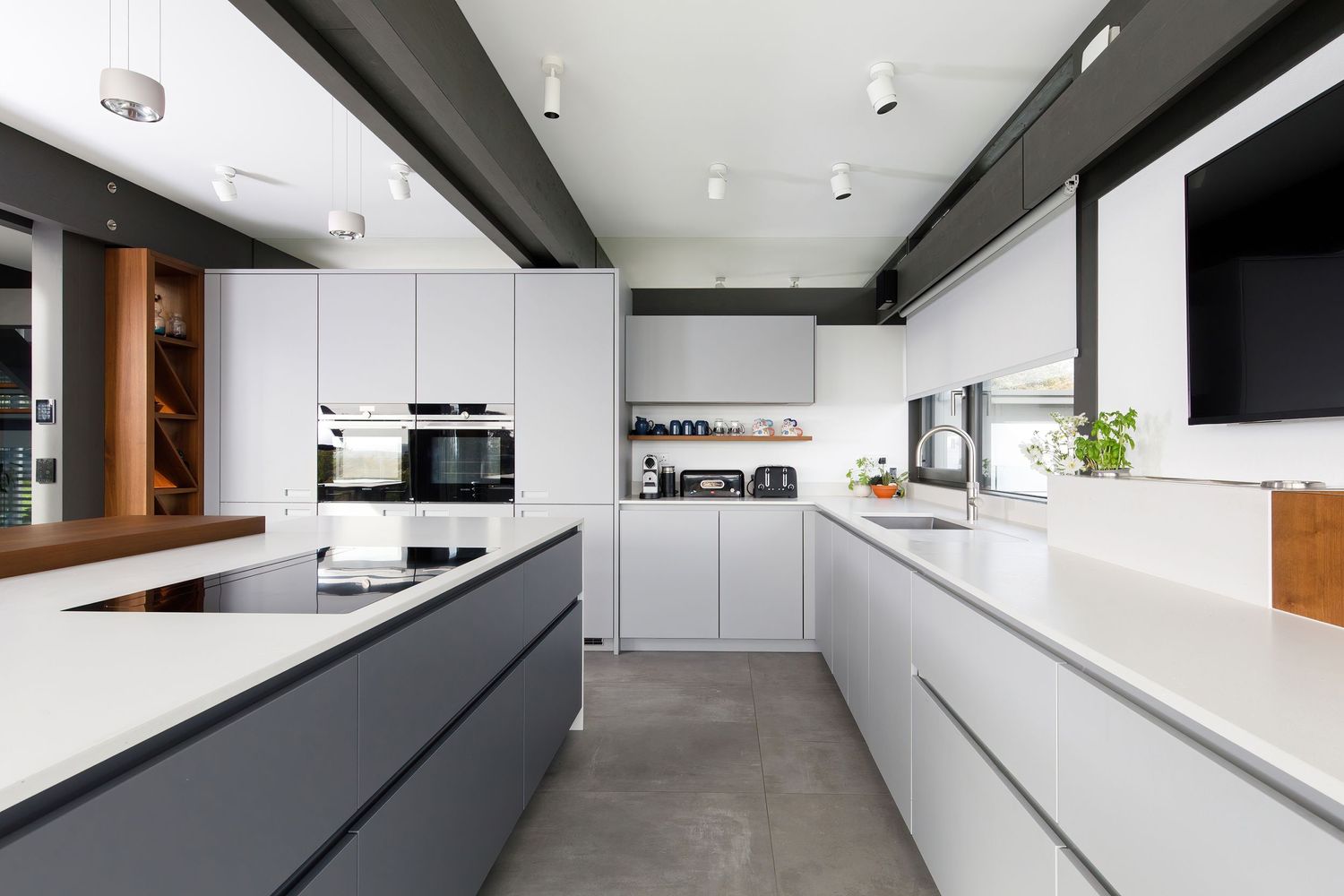 Sleek modern kitchen with white and grey cabinetry, quartz countertops, and integrated appliances