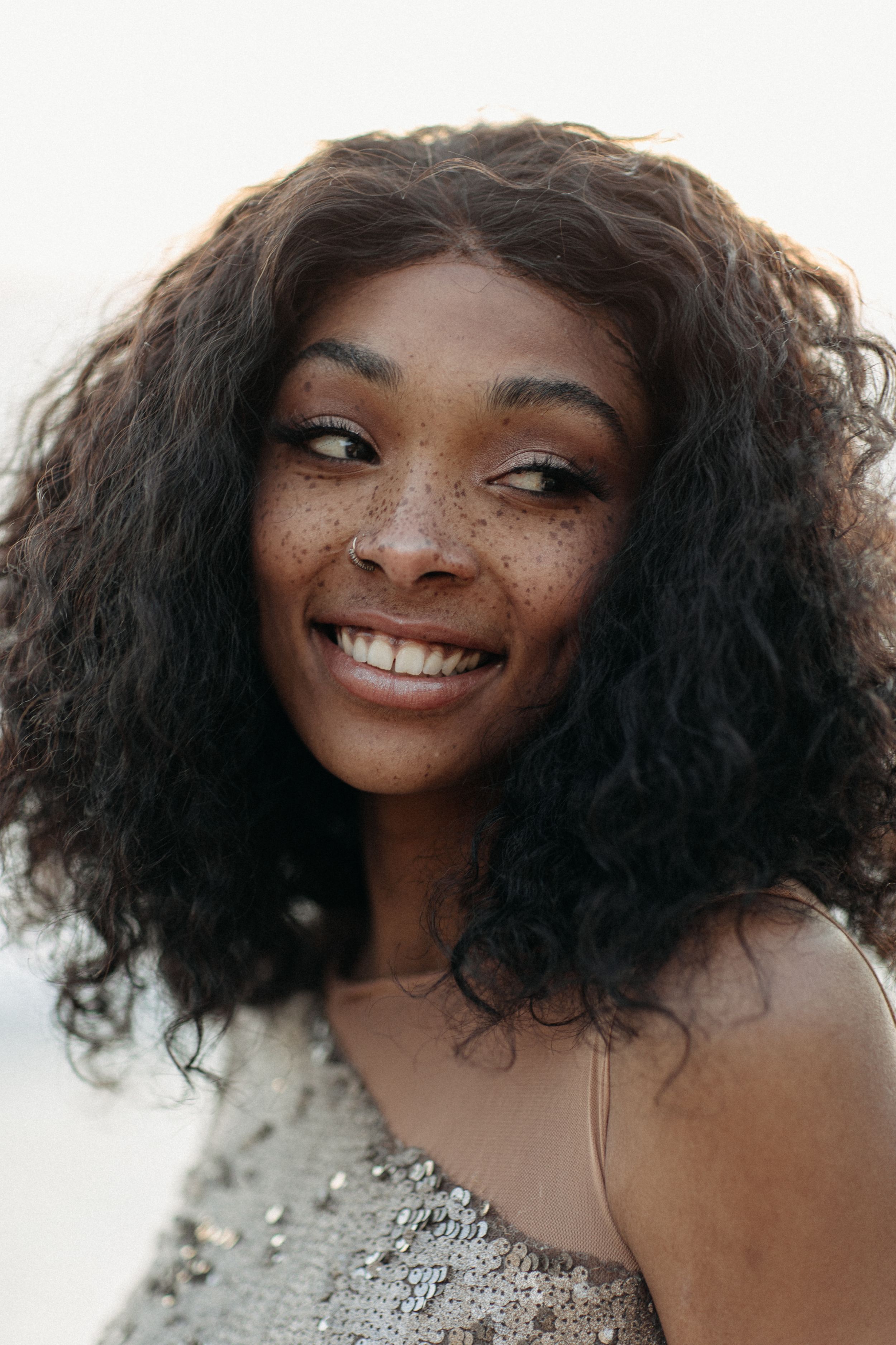 Glittering sequin dress captured in golden hour beach portrait.