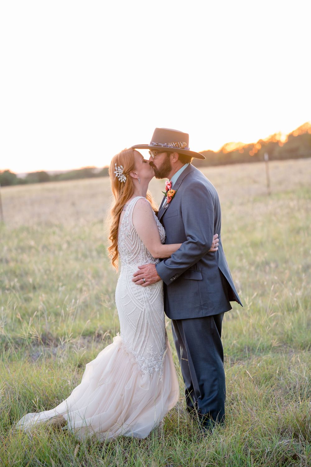 A romantic sunset portrait of newlyweds embracing in a golden field.