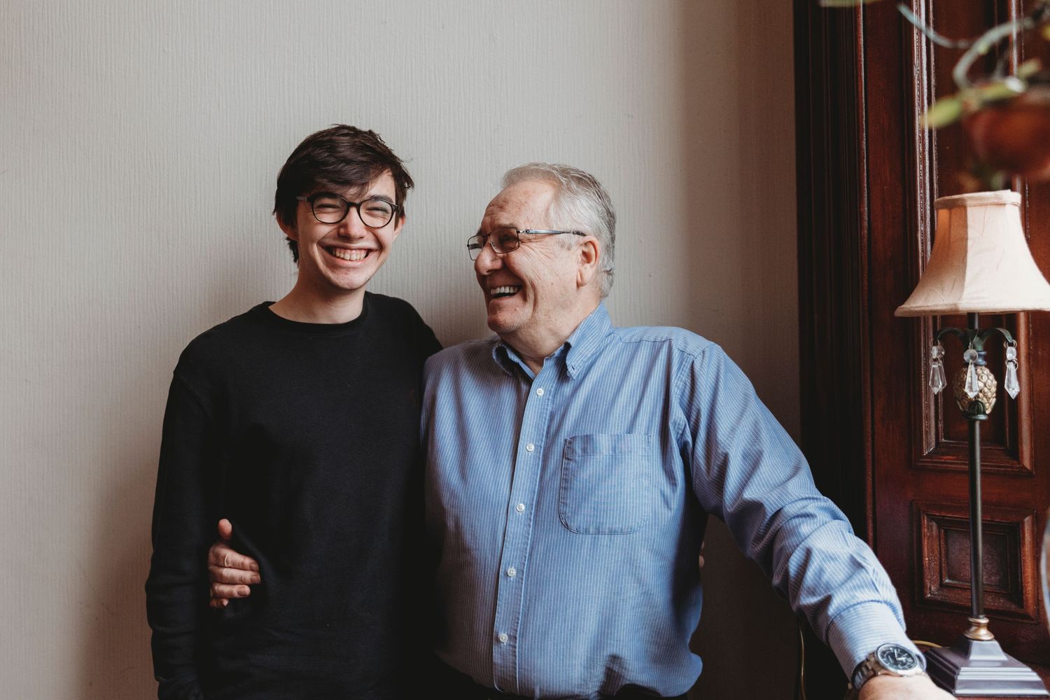 Two people sharing a joyful moment while standing together indoors.