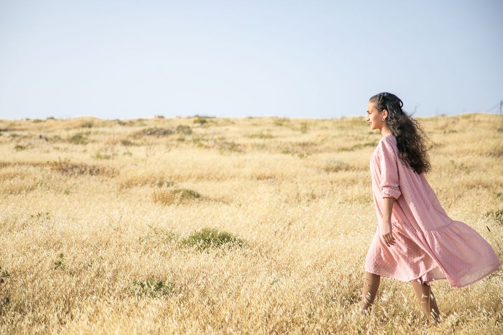 A girl walking in a golden field