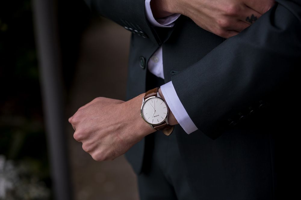 Groom in a Green wedding suit showing his new watch before his St.Leonards Vineyard winery wedding