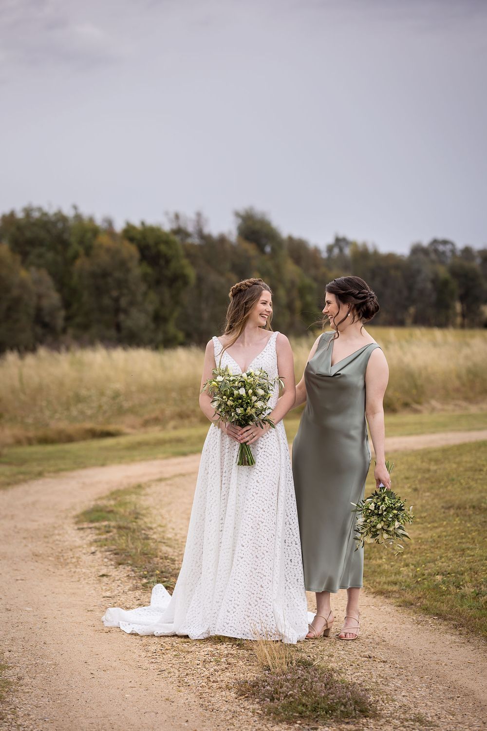 Bride in her wedding dress holding her flower bouquet with her Maid of Honour before her wedding ceremony at St.Leonards