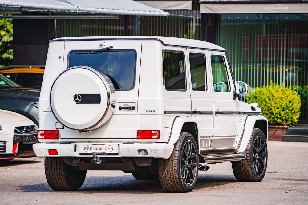 Rear quarter view of a white Mercedes G-Class SUV showing its boxy design and large wheels.