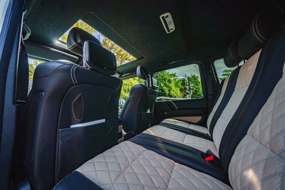 Black and white quilted leather interior of Mercedes G-Class showing rear passenger space.