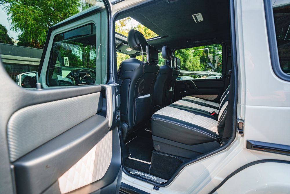 Open door view of Mercedes G-Class showing luxury interior and rear seat configuration.