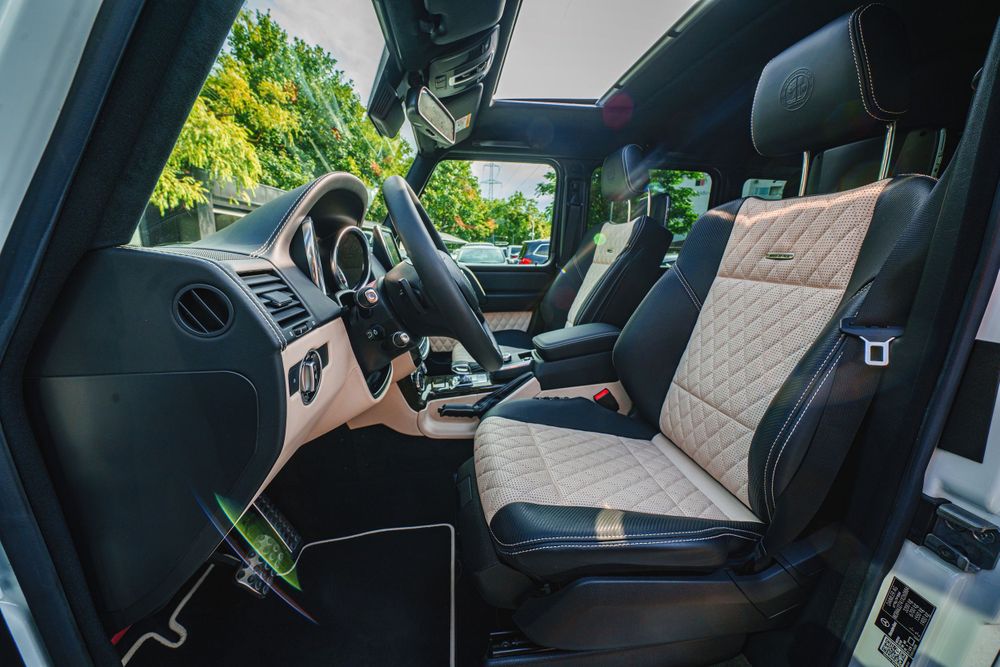 Luxury SUV interior featuring beige quilted leather seats and black dashboard controls.