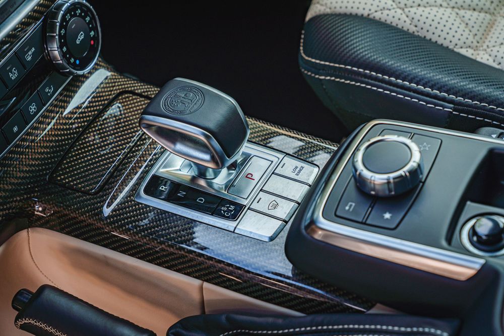 Carbon fiber center console with automatic gear shifter and infotainment control dial.