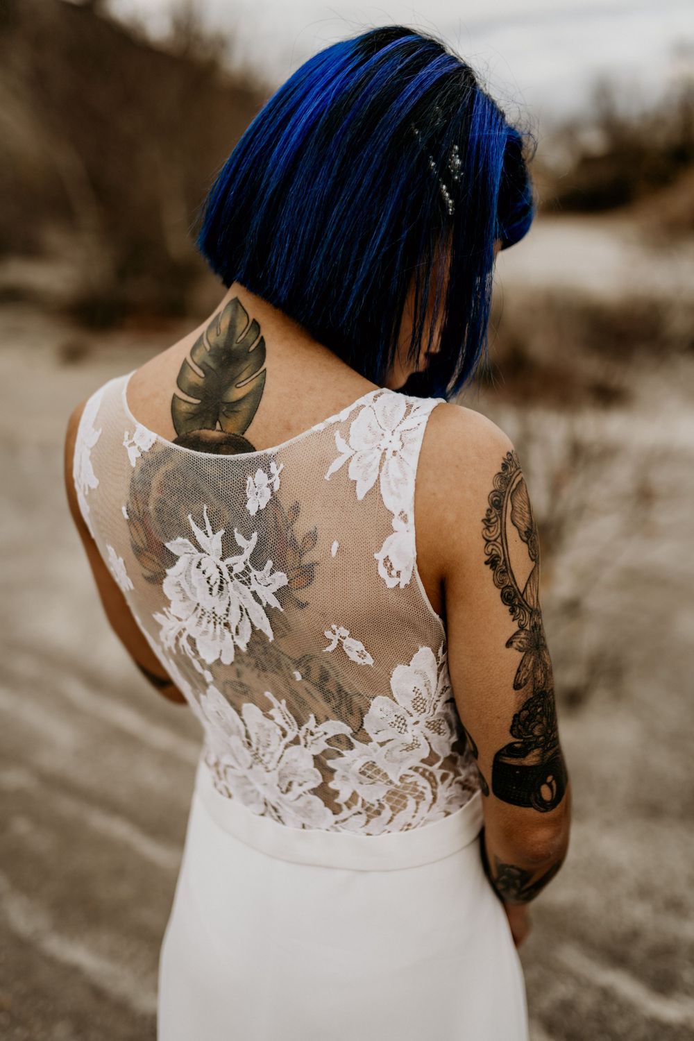 Dos d'une mariée tatouée au cheveux bleus