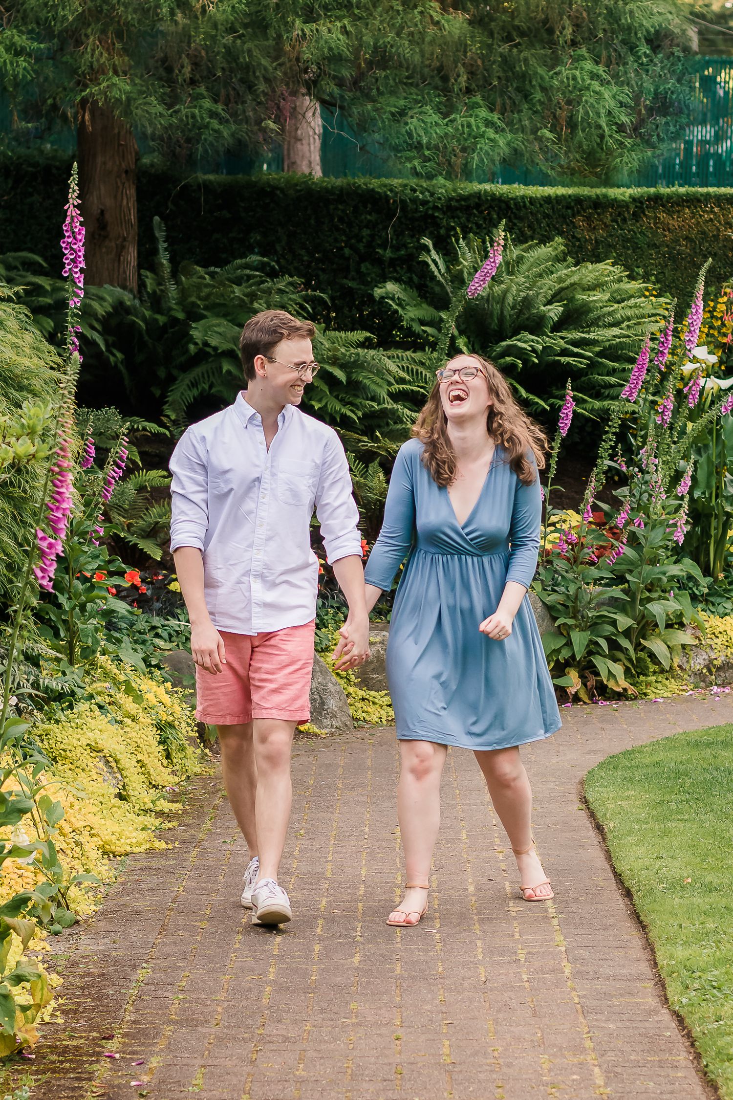 couple holding hands, couple, walking together, walking through a flower garden, couples portrait session, laughing, joy