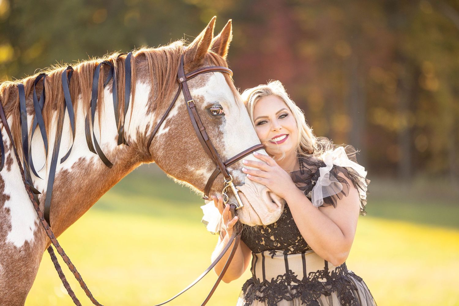 Girl in flowy dress with her paint mare in a field in the fall