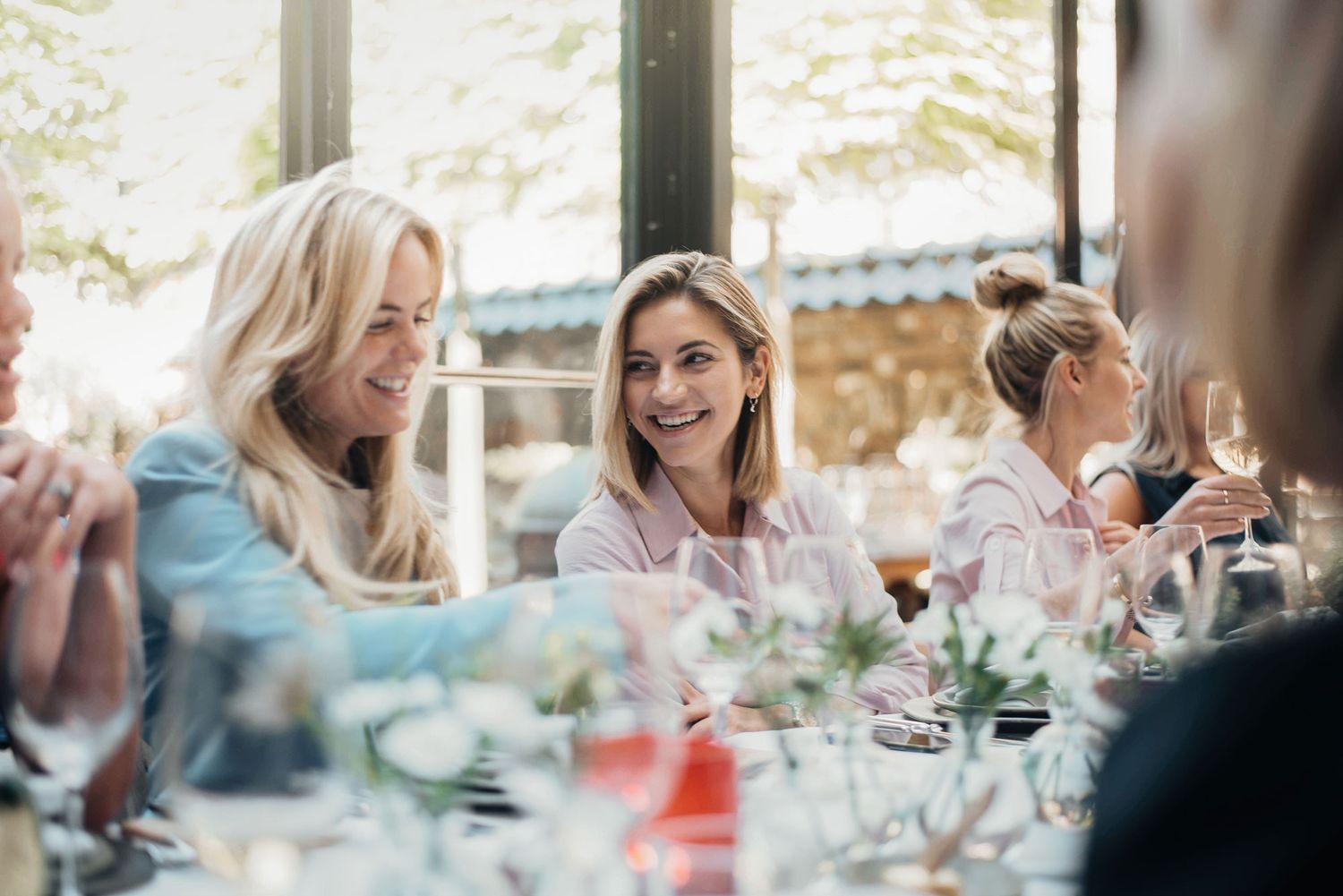 Friends enjoying a celebratory meal together at an outdoor dining table.