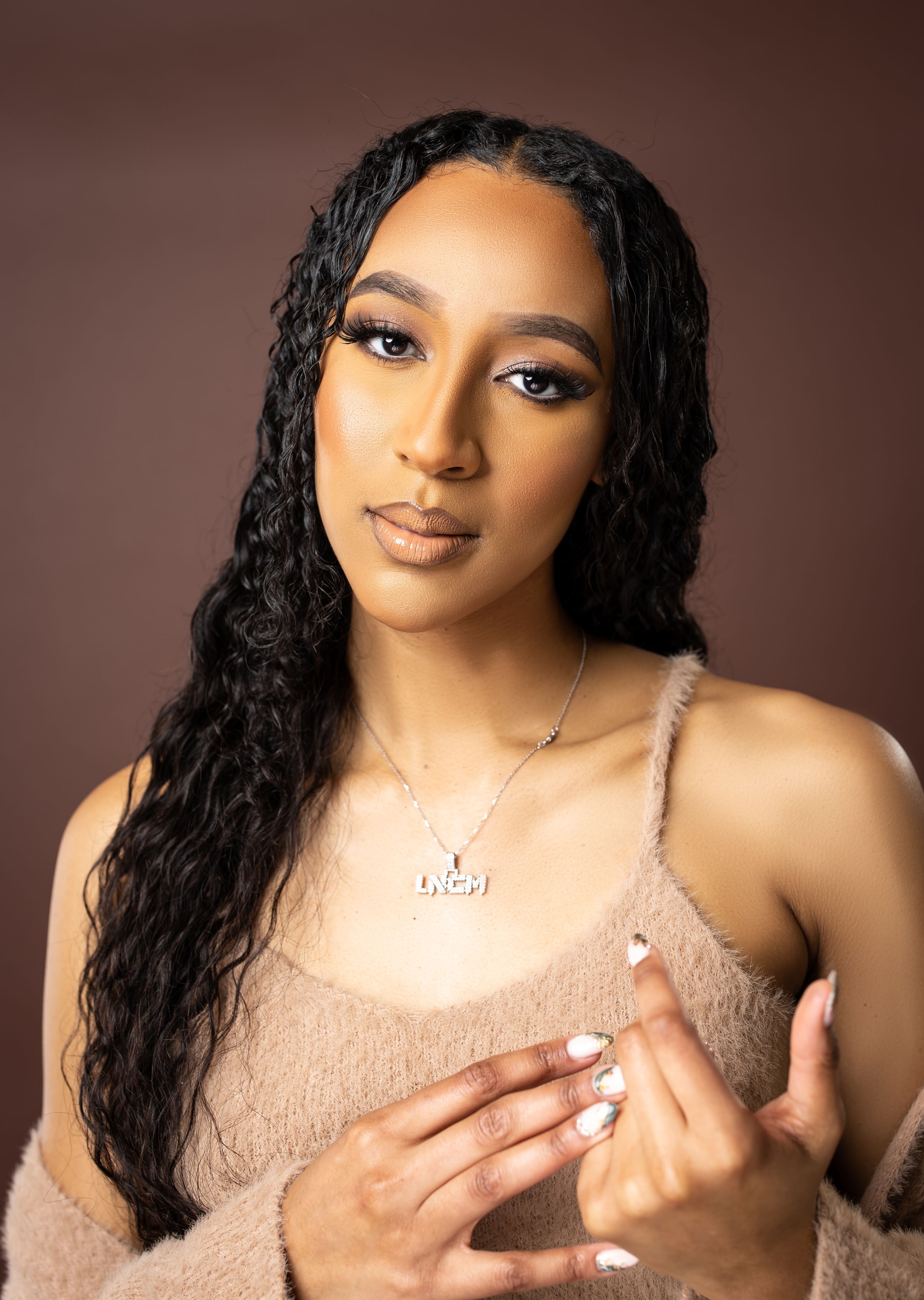 Close-up beauty portrait with long curls and neutral makeup.