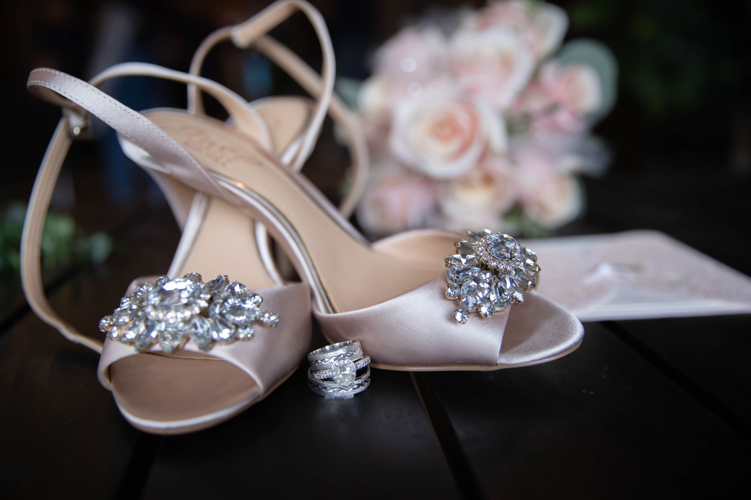 Blush pink bridal sandals with crystal embellishments and wedding ring.