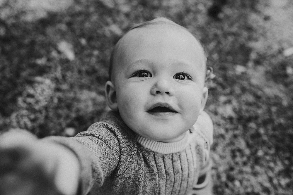Close up black and white portrait showing joyful expression and knit sweater.