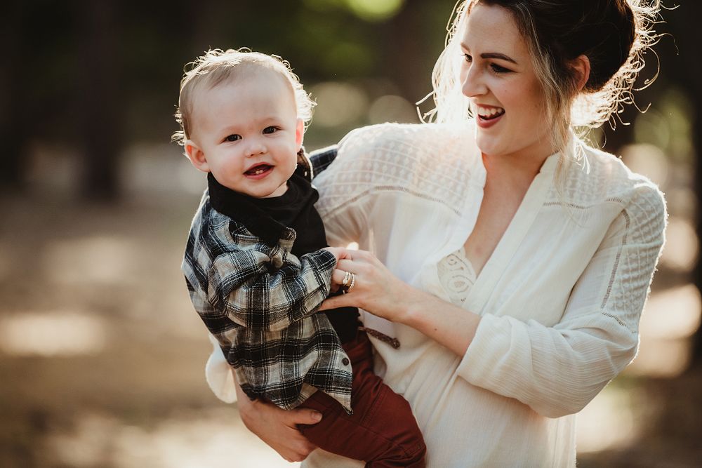Joyful moment shared in warm sunlight against natural backdrop.