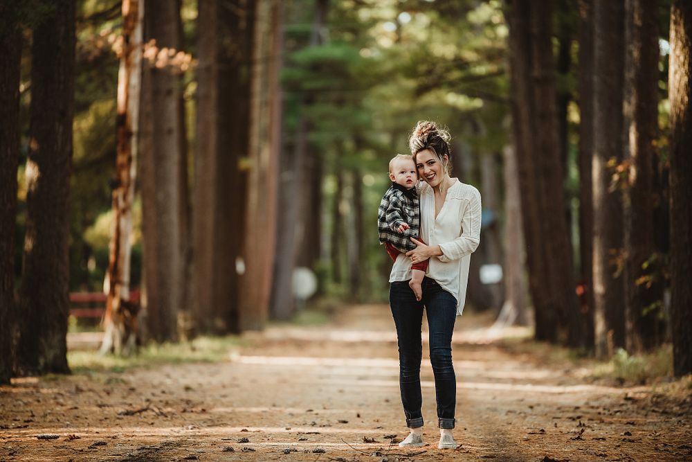 Tender moment captured on a scenic forest path lined with tall trees.