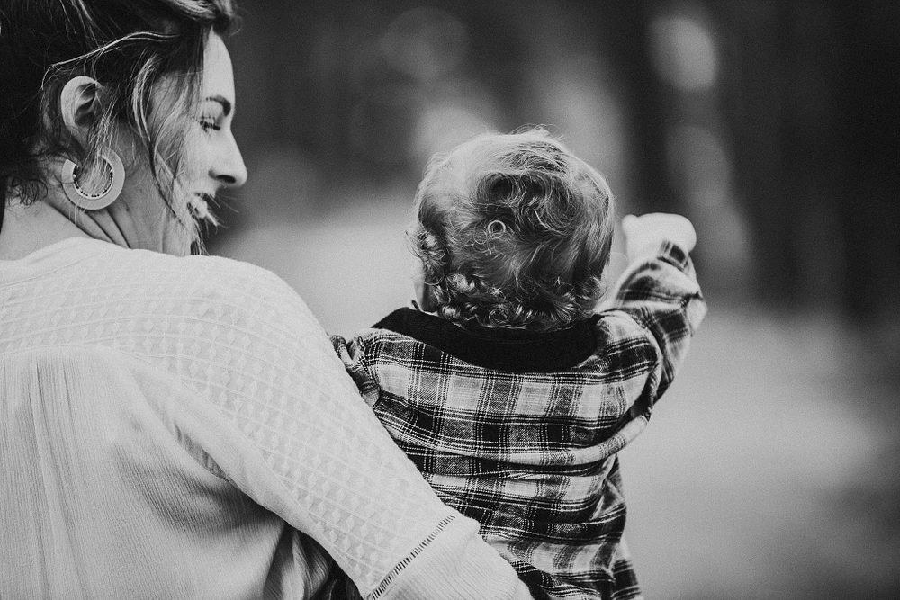 Black and white portrait of parent and child in plaid shirt looking to the side.