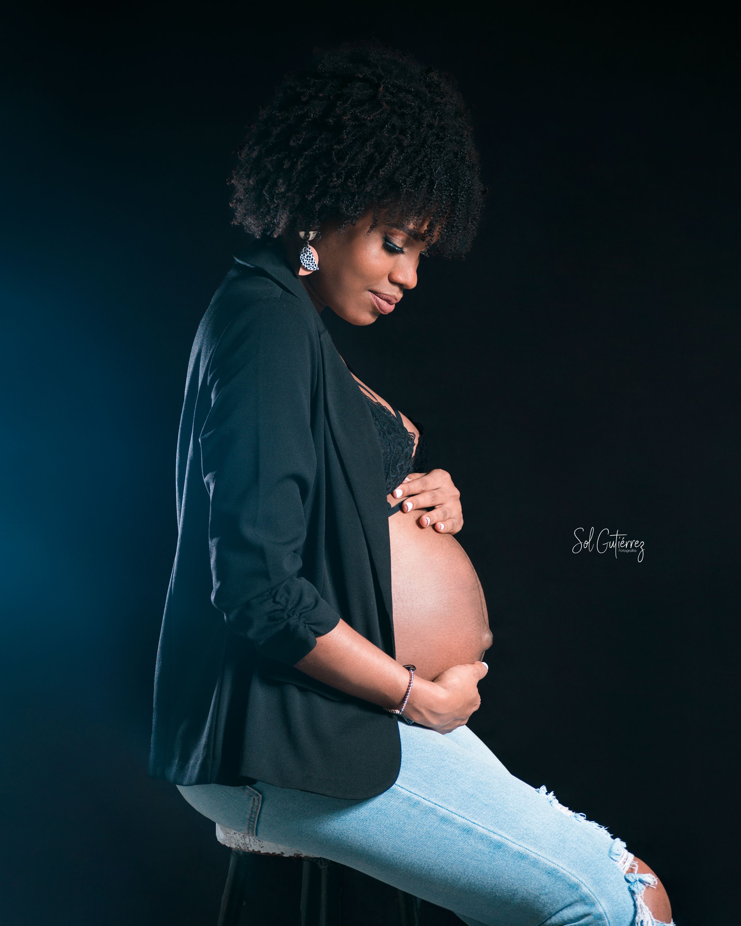 Maternity photography in Allentown PA of pregnant woman in casual outfit with blazer and soft studio lighting.