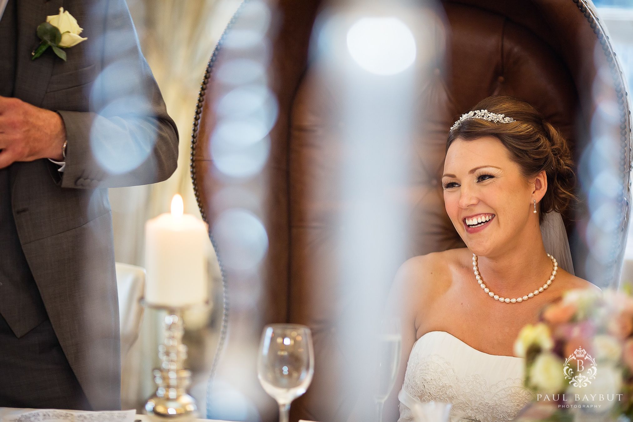 Candid reception moment with sparkly bokeh lighting effects in the background.
