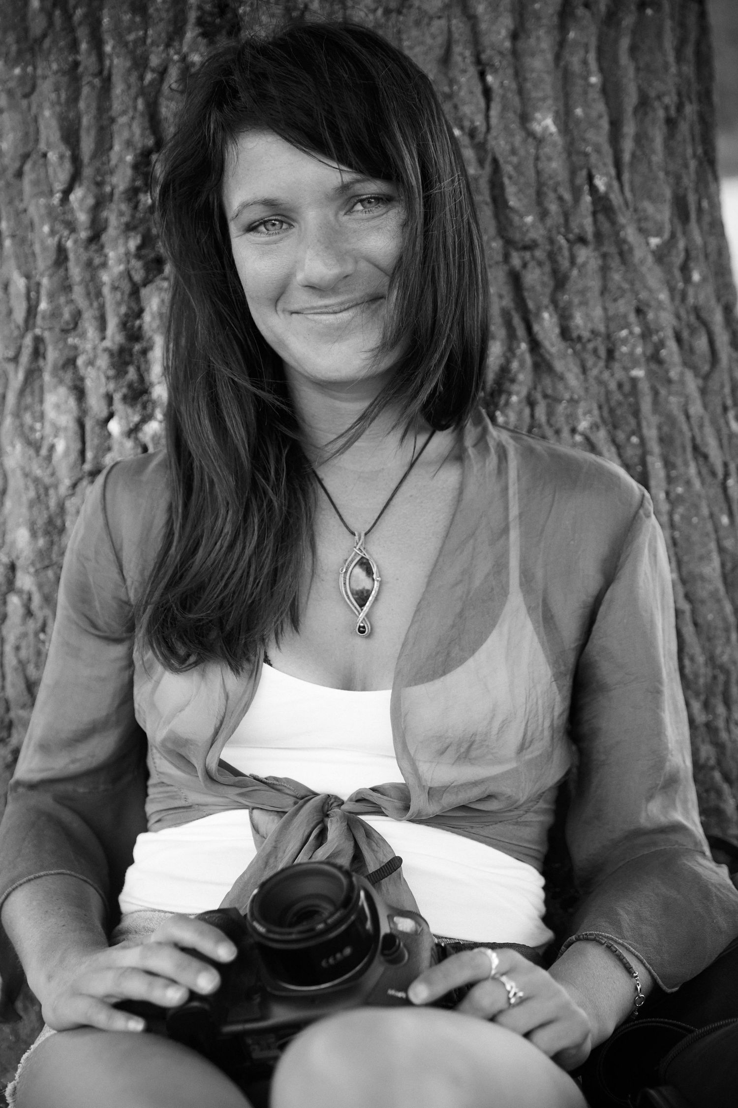 Photographer smiles with her camera on her lap
