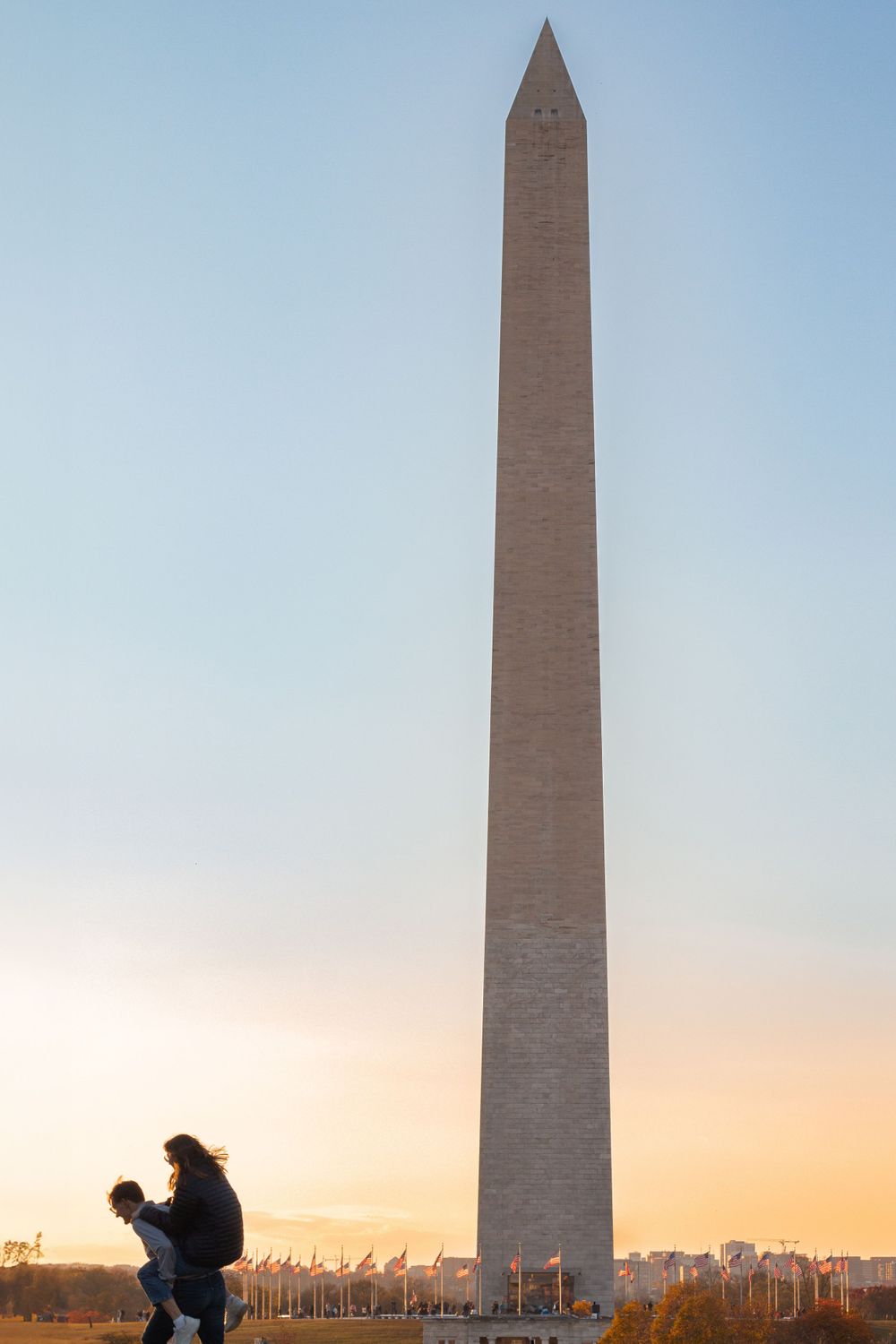 Two people run on the National Mall in front of the Washington Monument