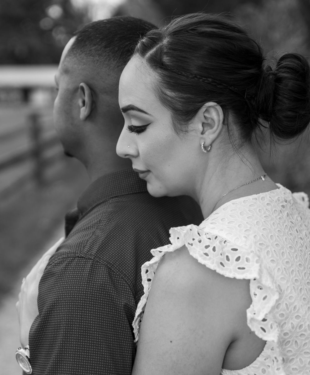 An intimate black and white portrait of a couple in white lace and dark clothing.