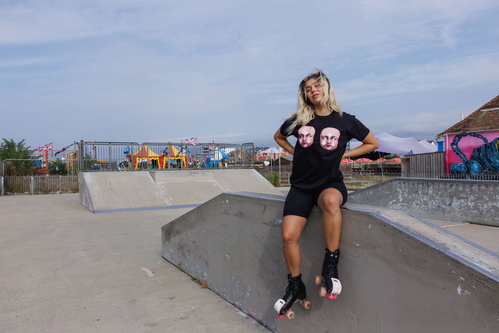 Shannon sitting in Hove Lagoon skatepark wearing roller skates and tee by Grunge Monkey