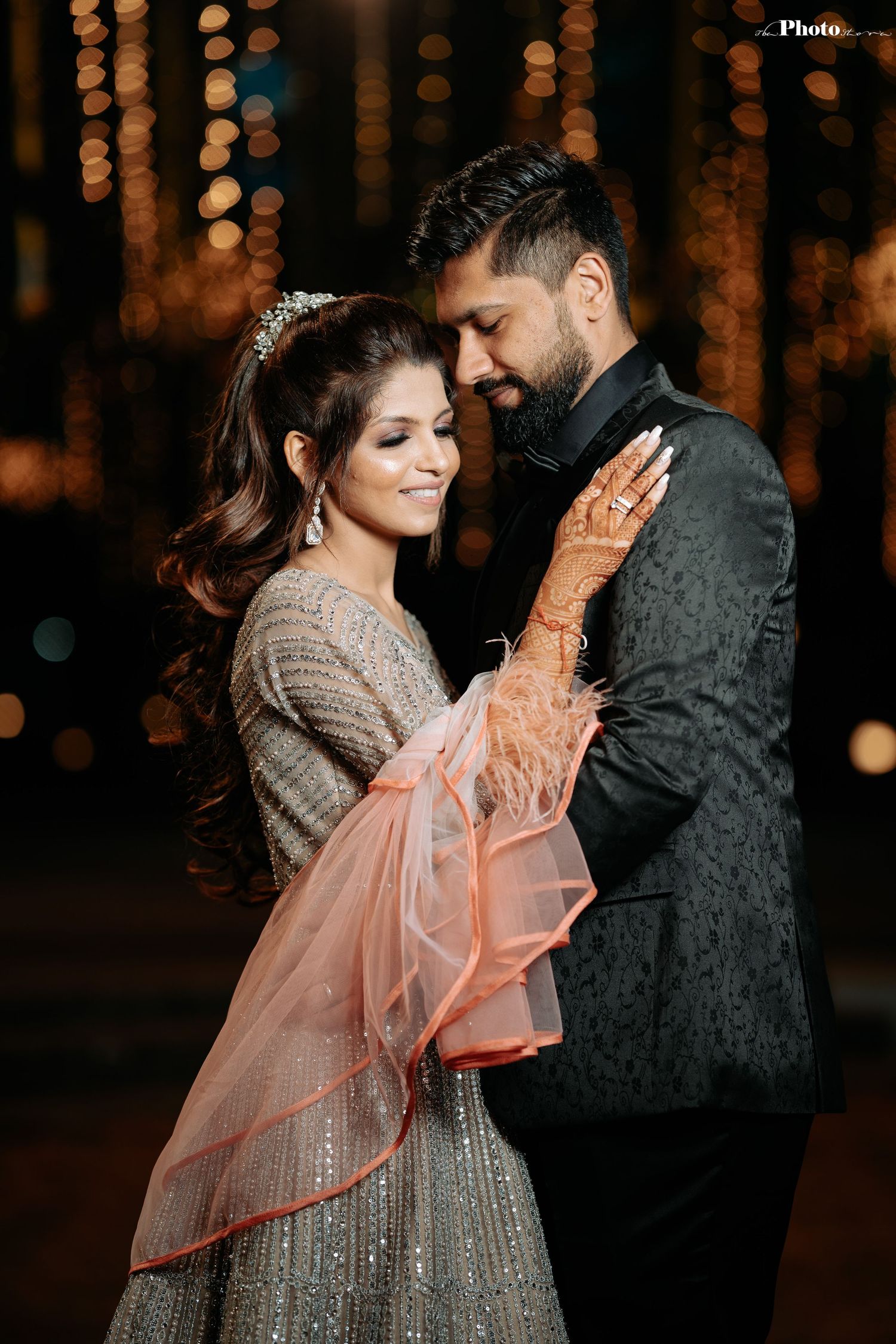 Romantic dance moment captured against a backdrop of glowing string lights at an evening celebration.
