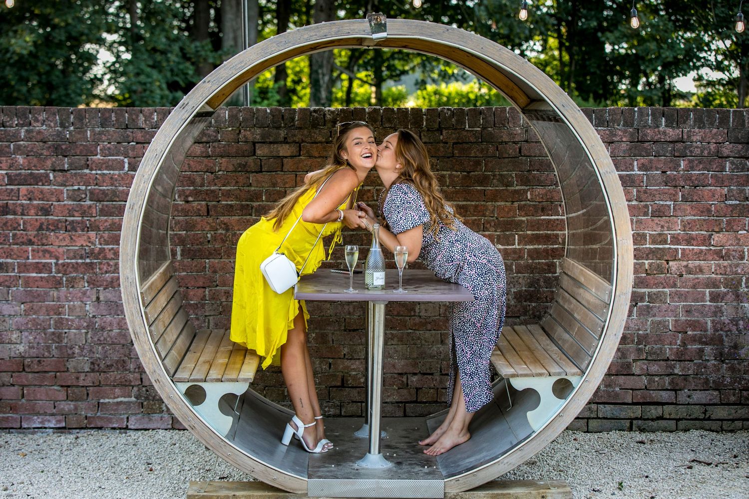 Couple sharing intimate moments through circular window frames against brick wall.