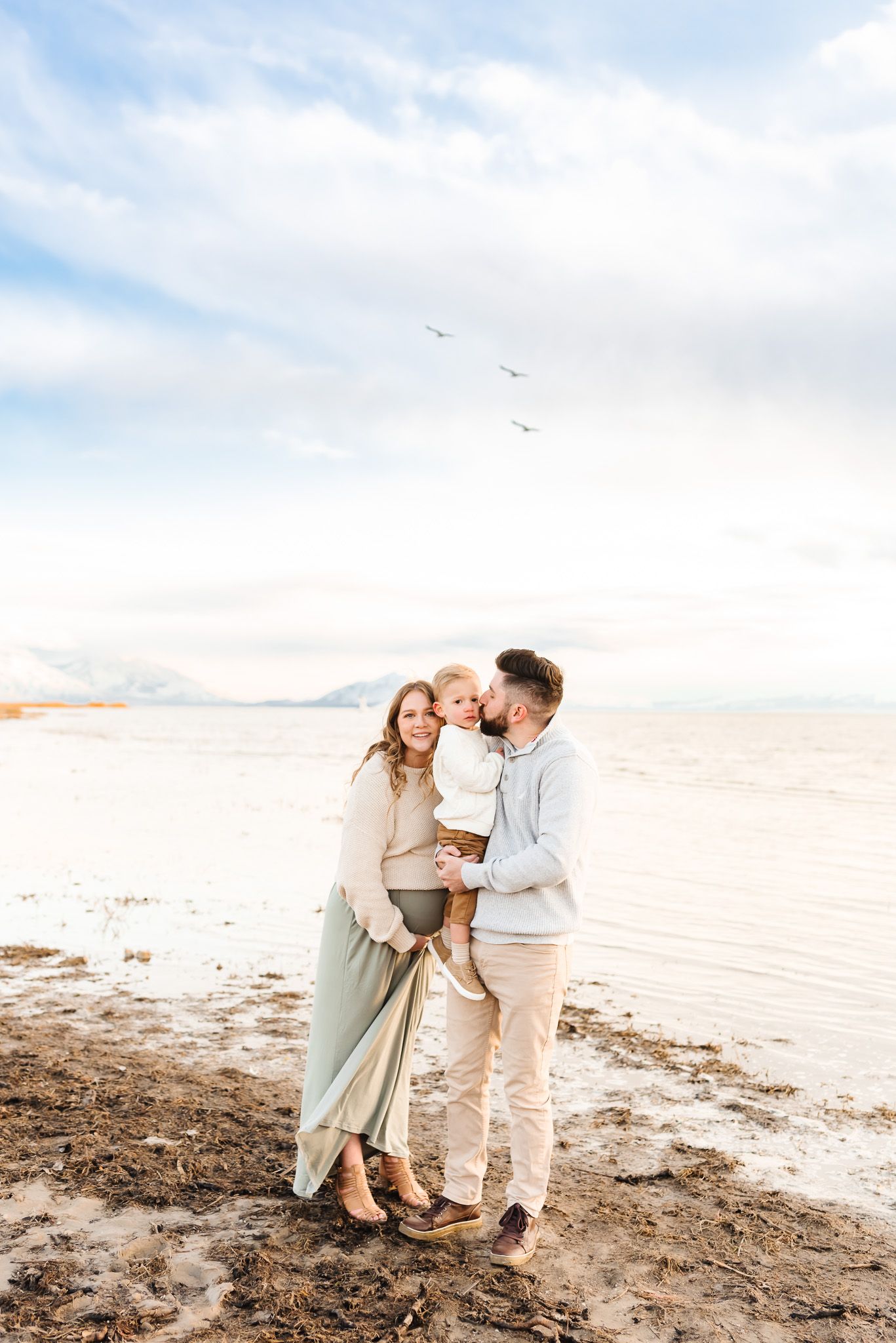 Family portrait session on beach showing intimate moments between loved ones at sunset.