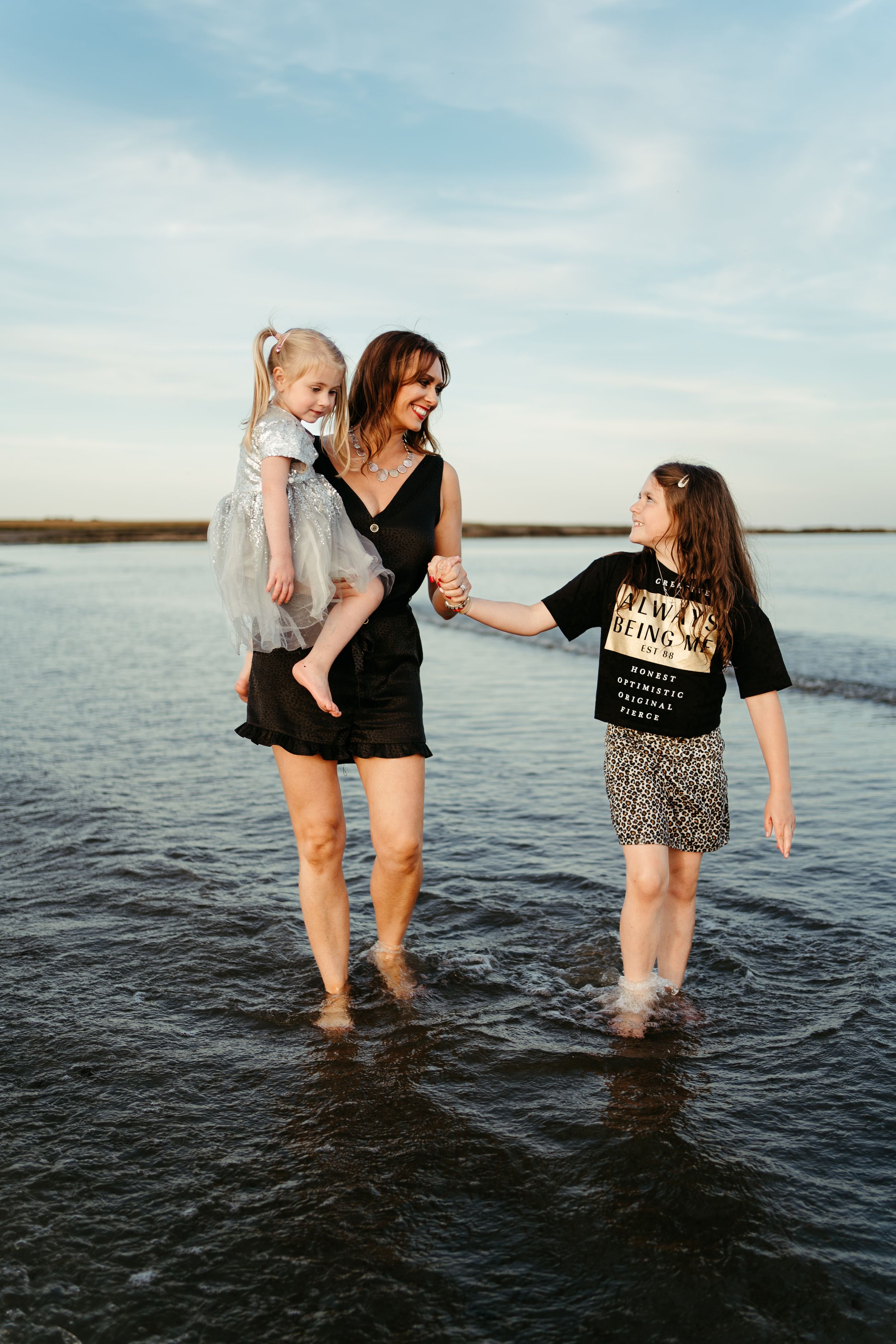 A fun family moment splashing in shallow water at sunset.