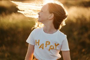 A person's hair flows in the wind during a golden hour photoshoot.