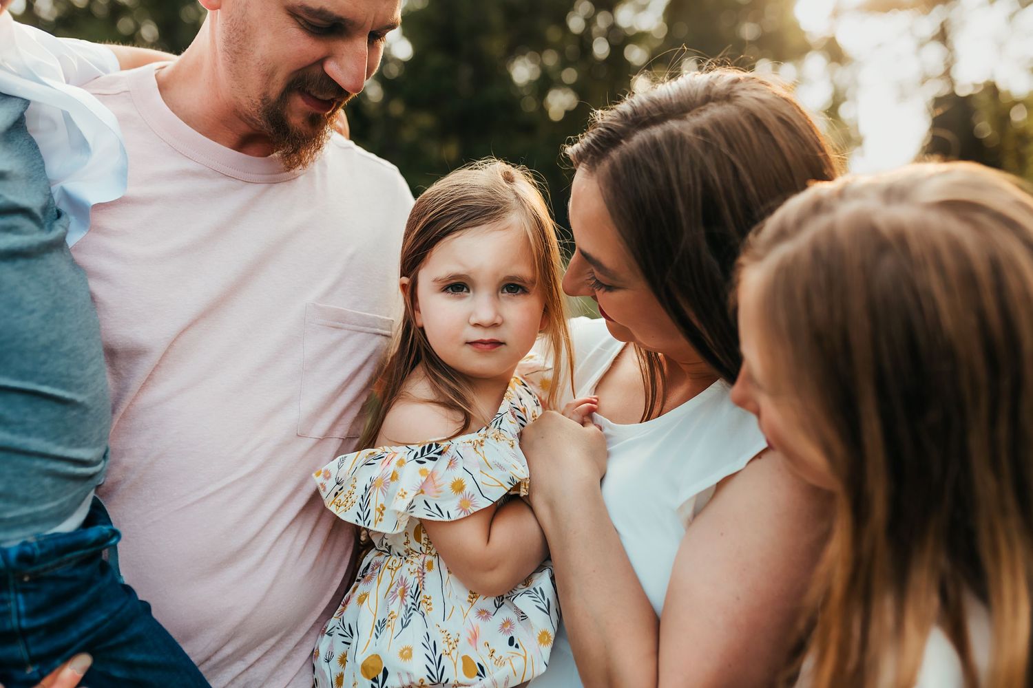 Intimate family moment captured outdoors during sunset.