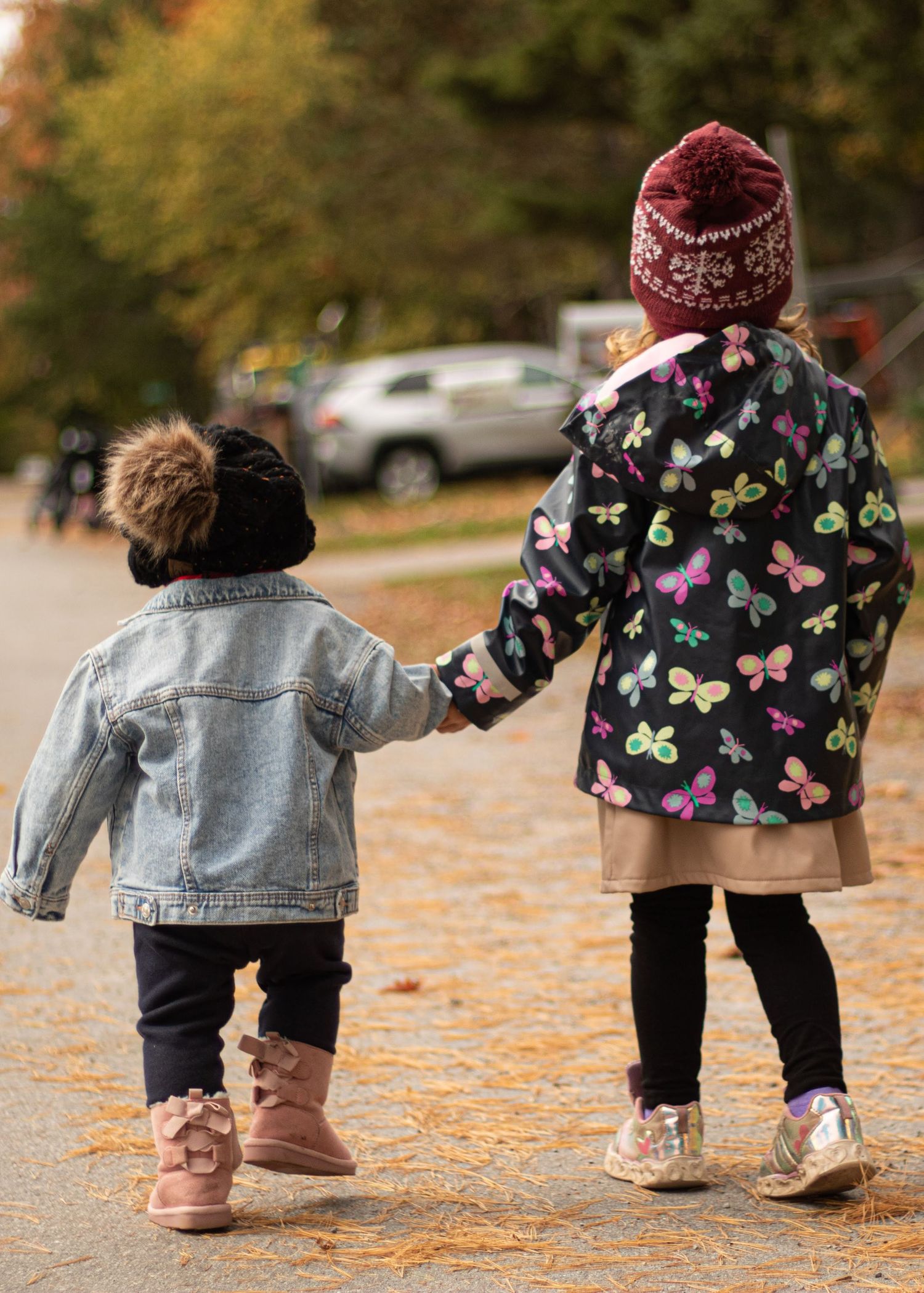 Two little kids holding hands while walking