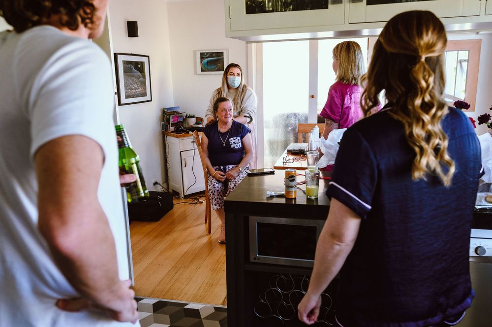 People gathered in a bright modern kitchen during a casual indoor gathering.