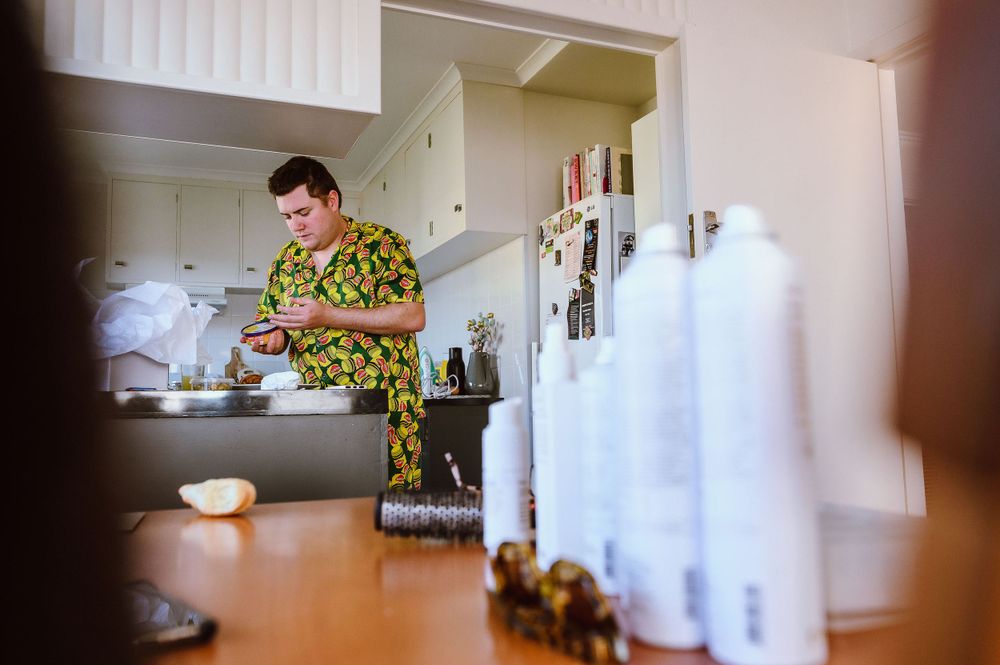 Someone in a patterned shirt preparing food in a bright modern kitchen.