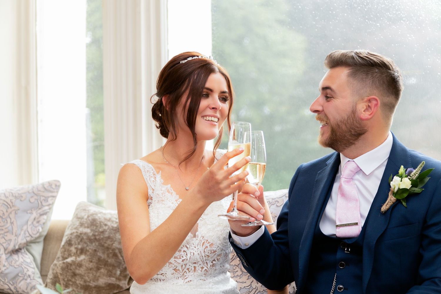 A couple toasting with champagne glasses in an elegant indoor setting.