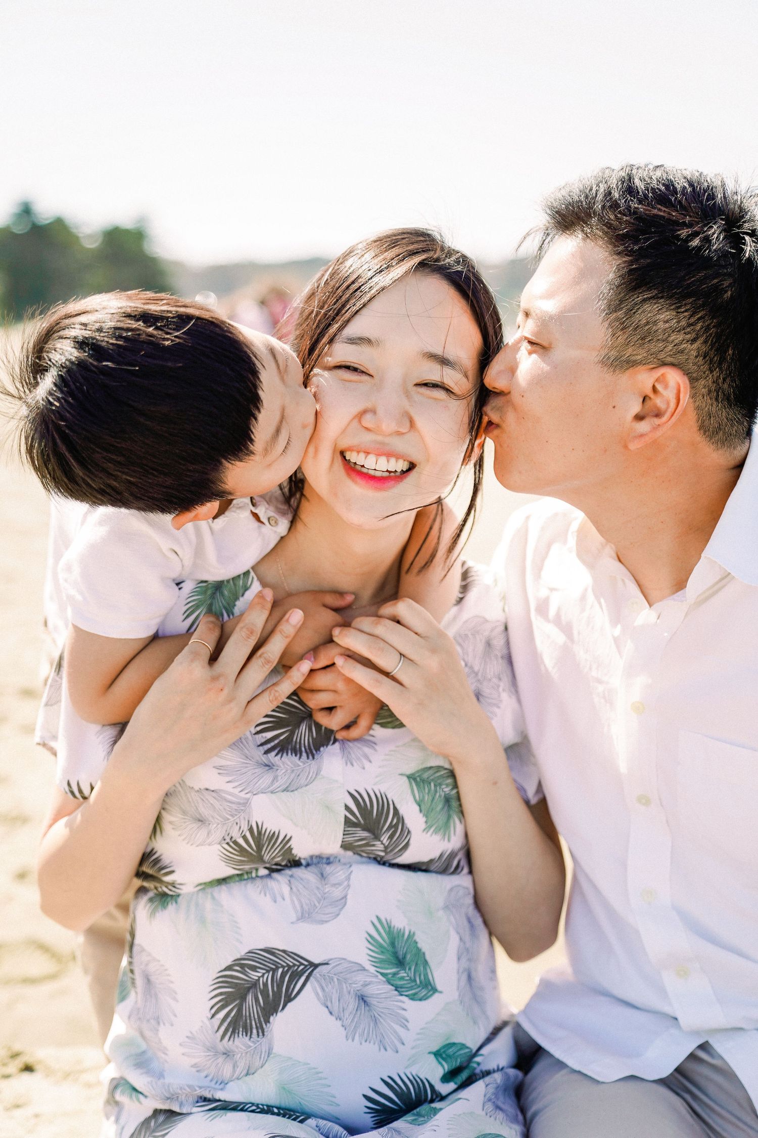 Joyful family sharing tender moment on sunny beach.