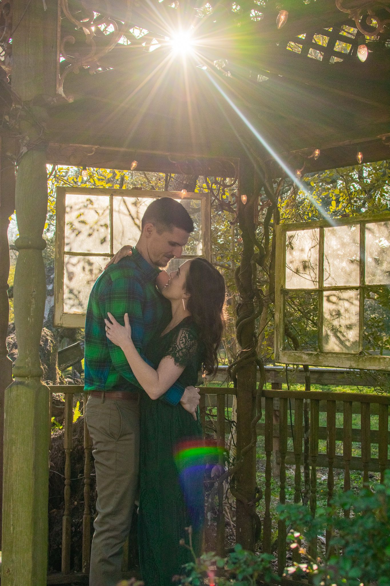 Sunlight streams through gazebo roof as couple shares intimate moment.