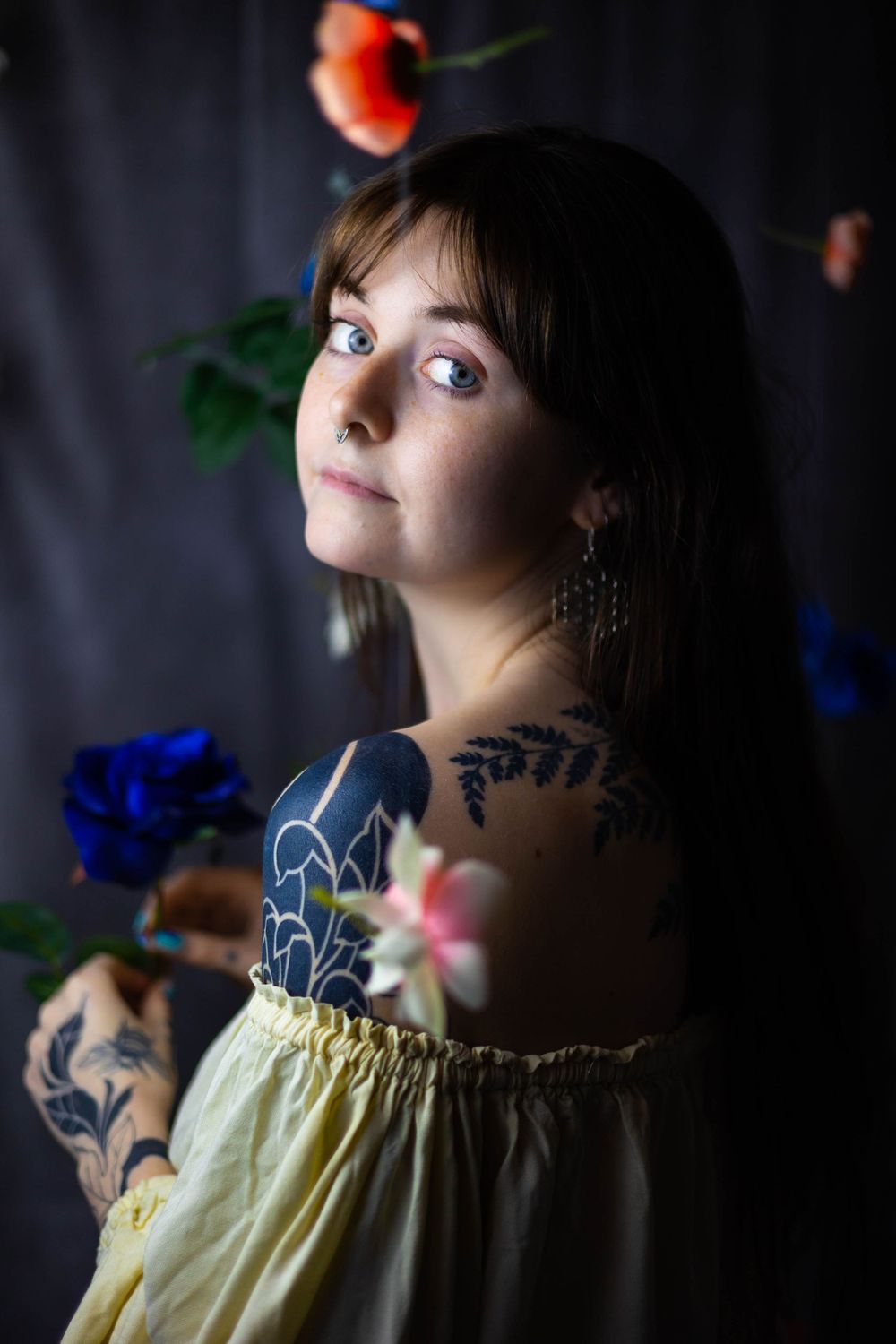 Artistic portrait series in dramatic lighting showing a yellow dress and dark tattoos.