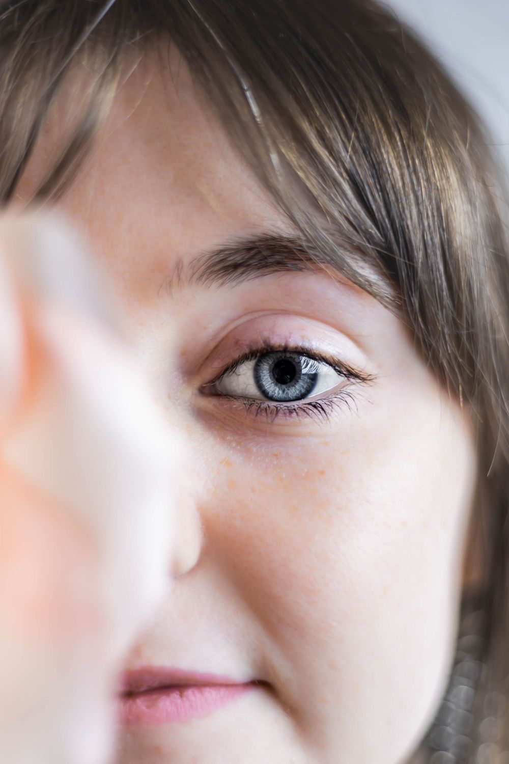 Artistic close-up photo showing eyes and facial features in soft lighting.