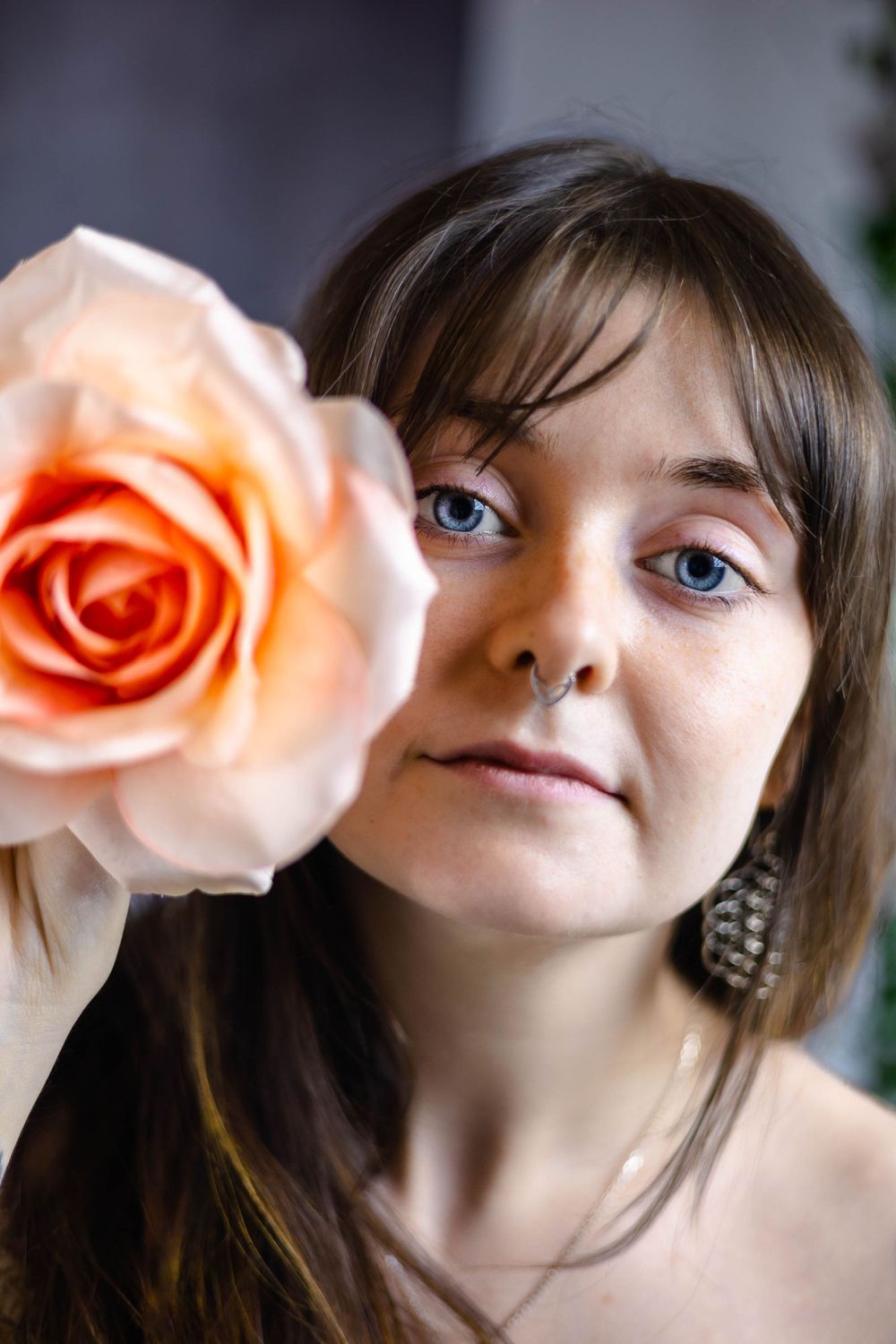 Artistic portrait with peach-colored roses creating a dreamy aesthetic.