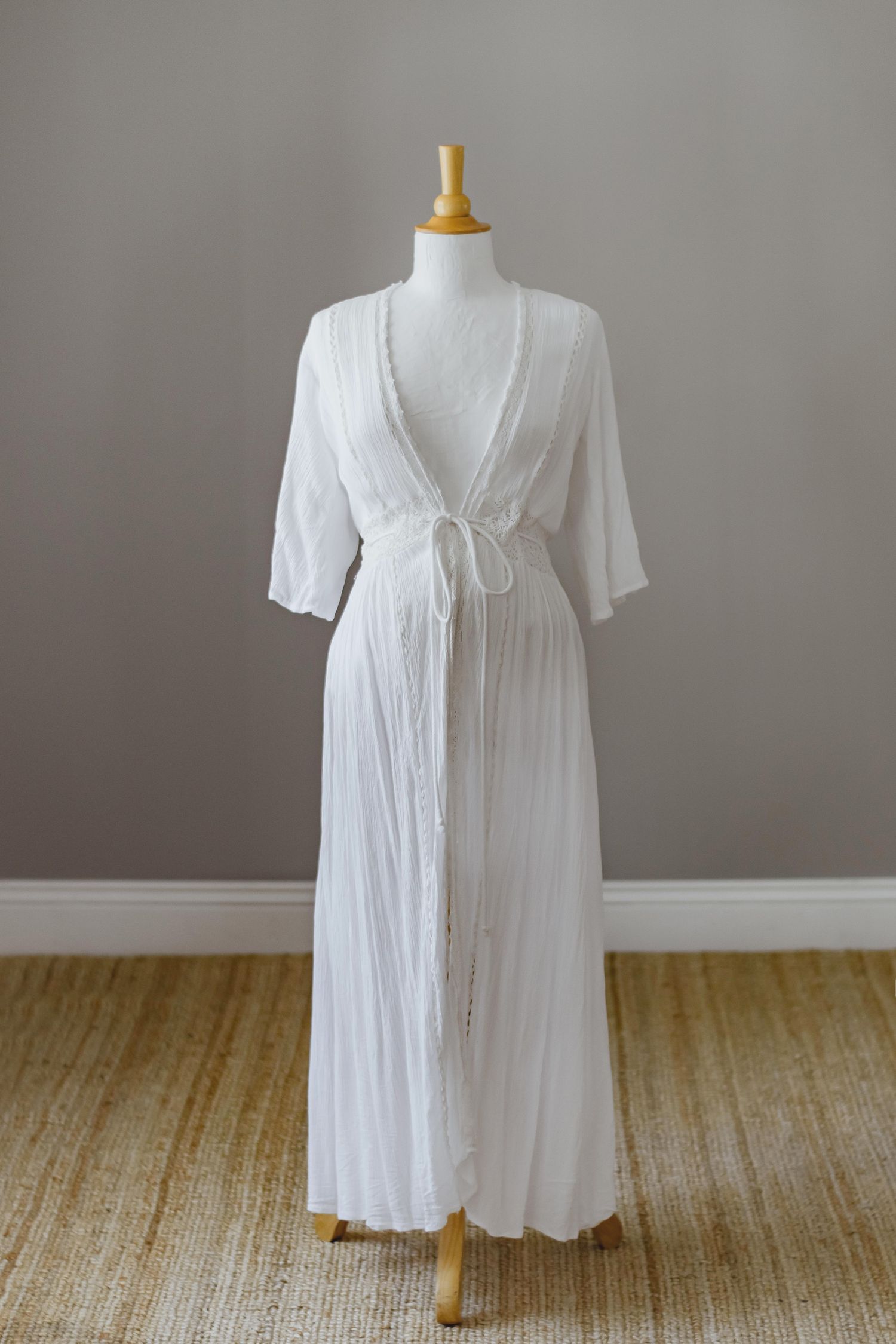 White cotton maternity robe with lace details and tie waist on display.