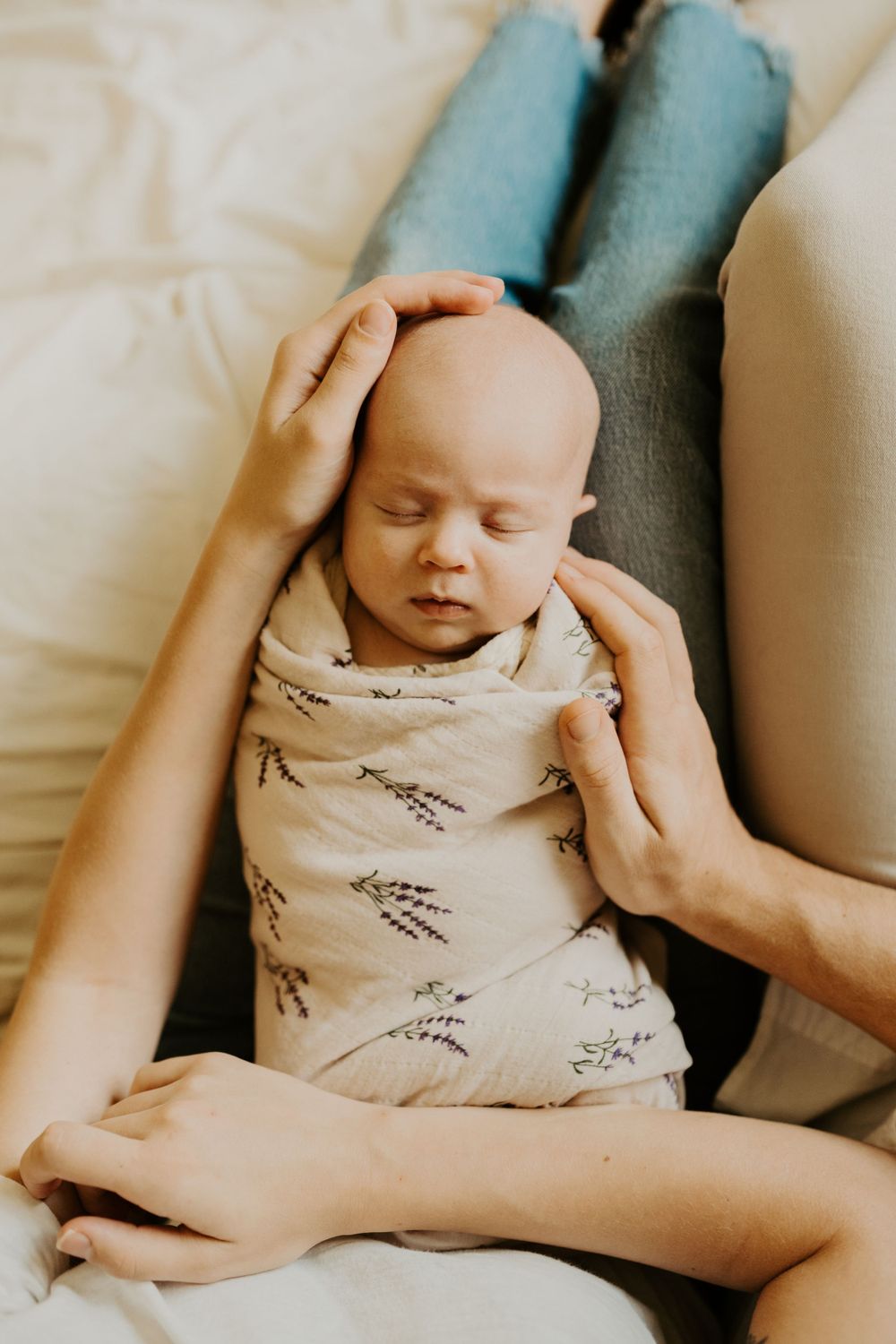 In-home newborn session. Photo of newborn wrapped up in parent's lap