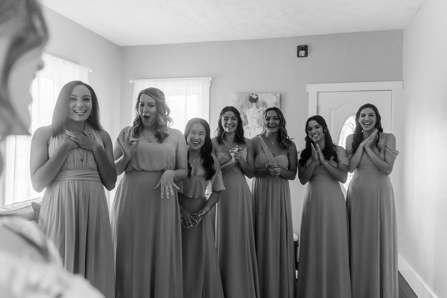 Bridesmaids in light blue dresses share joyful moments together indoors.